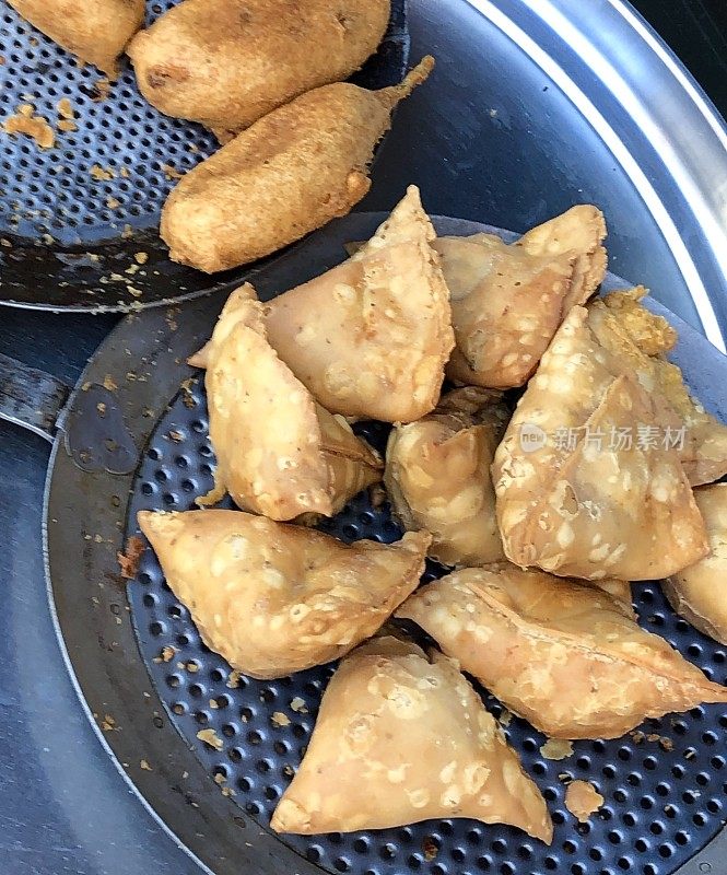 印度，油炸后的盘子上的印度街头小吃三角饺和青椒pakora / mirch pakora